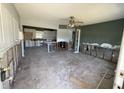 View of gutted living room and kitchen area, with natural light streaming in through the windows at 7366 Royal Palm Dr, New Port Richey, FL 34652