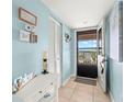 Bright condo entryway with tile flooring, decor, and a view to the community through the screen door at 8141 Aquila St # 342, Port Richey, FL 34668
