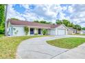 Beautiful home featuring a curved driveway, lush lawn, and a well-maintained exterior at 8513 Sunflower Ln, Hudson, FL 34667