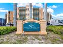 Regatta Beach Club signage, oceanfront residences, with beautiful landscaping and blue sky backdrop at 880 Mandalay Ave # N710, Clearwater Beach, FL 33767
