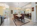 Elegant dining area featuring modern chandelier, large mirror, and natural light at 10510 Castleford Way, Tampa, FL 33626