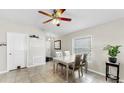 Well-lit dining room with a ceiling fan, table, four chairs, and a window with blinds at 11208 Leland Groves Dr, Riverview, FL 33579