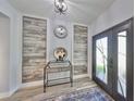 Stylish entryway features modern decor, wood-look floors, decorative wood paneling, and an ornate front door at 11407 Leland Groves Dr, Riverview, FL 33579