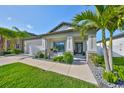 Inviting home with palm trees, stone accents, and a welcoming front porch and walkway at 11407 Leland Groves Dr, Riverview, FL 33579