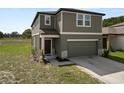 Inviting two-story house featuring neutral paint, a two-car garage, and a neatly landscaped front yard at 11530 Adam Lee Way, Dade City, FL 33525