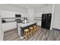 Bright kitchen featuring white cabinets, granite countertops, stainless steel appliances, and a central island with seating at 11530 Adam Lee Way, Dade City, FL 33525