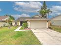 Charming single-story home features a well-manicured lawn, decorative landscaping, and an attached two-car garage at 1239 Tuxford Dr, Brandon, FL 33511