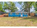 Charming blue home with stone accents, well-maintained lawn and mature trees at 1513 Escort Ave, Tampa, FL 33610