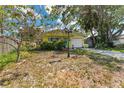 Lovely yellow one-story home with a bright blue front door, mature landscaping, and one car garage at 1782 Maryland Ne Ave, St Petersburg, FL 33703