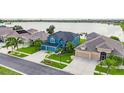 Aerial view showcases a beautiful blue home next to a lake and well-maintained landscaping at 1806 Mira Lago Cir, Ruskin, FL 33570
