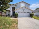 Charming blue home with a two-car garage, manicured lawn, and blue front door at 1830 Citrus Orchard Way, Valrico, FL 33594