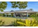The rear of the home displays a spacious screened lanai, lush lawn, and verdant landscaping at 1909 E View Dr, Sun City Center, FL 33573