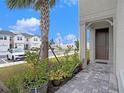 Stylish townhome entrance with a paved walkway, lush landscaping, and a charming front door at 19153 Elsimont Isle, Lutz, FL 33558