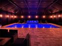 Stunning indoor pool featuring lounge chairs, water features, and elegant lighting at 21422 Draycott Way, Land O Lakes, FL 34637