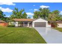 Inviting single-story home with a two-car garage, manicured lawn, and attractive exterior details at 2719 Cypress Hollow Ct, New Port Richey, FL 34655