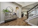 Welcoming foyer with tile floors, decorative console table, staircase and open view to living spaces at 29002 Trevi Pl, Wesley Chapel, FL 33543