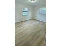 Bright bedroom showcasing new floors and natural light from two windows at 3009 S Willow Dr, Plant City, FL 33566