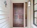 Solid wood front door with sidelight and decorative butterfly accent at 3182 Windmoor N Dr, Palm Harbor, FL 34685