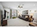 Cozy living room with plush leather sofa, ceiling fan, and large windows at 37673 Dixie Ave, Dade City, FL 33525