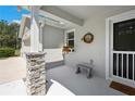 Inviting front porch with stone pillar, wreath, flower box, and a bench at 37673 Dixie Ave, Dade City, FL 33525