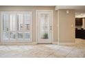 Bright foyer with decorative glass front door, neutral tile flooring, and large window with shutters at 4230 Hartwood Ln, Tampa, FL 33618