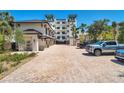 Beautiful exterior view showing the ample brick parking area with lush landscaping of this multi-Gathering home at 455 Pinellas Bayway S # 2B, Tierra Verde, FL 33715