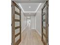 Bright hallway featuring stylish wood-look floors, modern lighting, and elegantly paneled wood doors at 455 Pinellas Bayway S # 4A, Tierra Verde, FL 33715