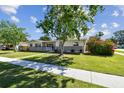 Well-kept single-story home with a mature tree and lush green lawn at 5601 16Th N St, St Petersburg, FL 33703