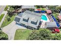 Aerial view of home showcasing solar panels, spacious lot, driveway, private pool, and outdoor entertaining area at 9201 86Th Ave, Seminole, FL 33777