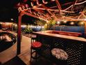 Outdoor poolside bar with overhead lighting and seating for entertaining in a relaxing backyard setting at 9201 86Th Ave, Seminole, FL 33777