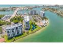 Gorgeous aerial view of waterfront condos with a marina, pool, and stunning lake views at 9495 Blind Pass Rd # 406, St Pete Beach, FL 33706