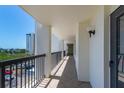 A long outdoor condo balcony showing the parking lot and another condo building nearby at 9495 Blind Pass Rd # 406, St Pete Beach, FL 33706