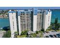 Exterior view of a luxurious waterfront condominium featuring multiple balconies and parking at 9495 Blind Pass Rd # 406, St Pete Beach, FL 33706