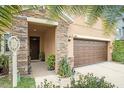Inviting front entrance with stone accents, a dark wood door, and well-maintained landscaping for a welcoming feel at 11818 Valhalla Woods Dr, Riverview, FL 33579