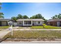 Lovely home featuring a well-kept lawn, mature trees, and neutral exterior paint at 12597 Cumberland Dr, Largo, FL 33773