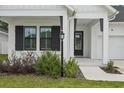 Charming front entrance with a black door, black shutters and a manicured front yard at 13460 Bergamont Cir, Tampa, FL 33618