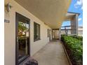 An exterior hallway with a beige textured wall and a front door. Stairs going to the second level at 135 Nina Way # 35, Oldsmar, FL 34677