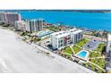 Waterfront condominium building with pool and beach access on a sunny day at 1400 Gulf Blvd # 511, Clearwater Beach, FL 33767