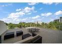 Spacious outdoor balcony with comfortable seating, panoramic views, and a blue sky with white clouds at 145 Belleview Blvd # 201, Belleair, FL 33756