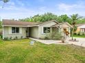 Inviting single-story home with neatly landscaped yard and pathway leading to the front door at 16116 Manorwood Cir, Tampa, FL 33624
