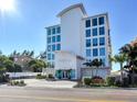 Modern building with bright white exterior, large impact windows and lush tropical landscaping at 19816 Gulf Blvd # 602, Indian Shores, FL 33785