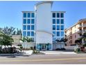 Contemporary building showcasing a clean white facade and large impact-resistant windows and lush landscaping at 19816 Gulf Blvd # 602, Indian Shores, FL 33785