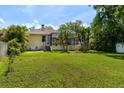 Expansive backyard featuring a well maintained lawn and tropical trees at 209 Arlington E Ave, Oldsmar, FL 34677