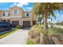Inviting two-story townhouse with attached garage, lush landscaping, and well-maintained front yard at 2227 Golden Falcon Dr, Ruskin, FL 33570