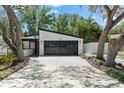 Contemporary home featuring a two-car garage with a sleek, dark-colored door and modern architectural details at 2257 Lake Dr, Dunedin, FL 34698