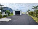 Wide driveway leads to a large steel building/garage featuring a blue doorframe at 3302 W Shell Point Rd, Ruskin, FL 33570