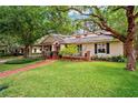 Charming home featuring a well-manicured lawn, cozy front porch, and mature trees at 3408 W San Jose St, Tampa, FL 33629