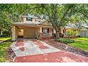 Charming home featuring a brick driveway, carport, and a cozy front porch at 3408 W San Jose St, Tampa, FL 33629