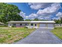 Charming single-story home features a two-car garage, brick accents, and a long driveway with a unique compass design at 39407 Rockford Ave, Zephyrhills, FL 33542