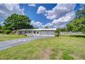 Charming single-story home features a two-car garage, brick accents, and a long driveway with a unique compass design at 39407 Rockford Ave, Zephyrhills, FL 33542